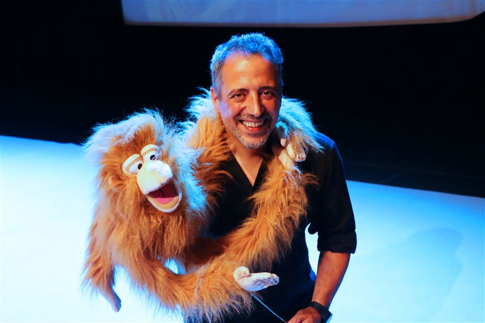 João Seabra em palco com um boneco de macaco